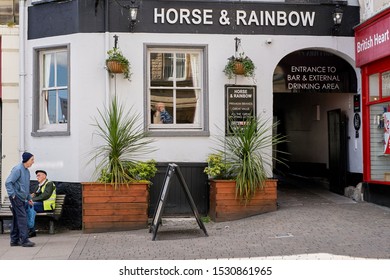 Kendal, Cumbria, UK - Circa March 2019: Streetscene With 2 Males In Front Of The Horse And Rainbow Pub