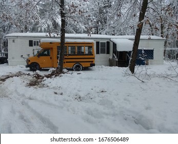 Kennebunk, ME / USA - 03 18 2020: Mini School Bus In Front Of Mobile Home In Winter Being Converted To Tiny Home On Wheels.