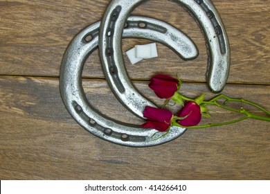 Kentucky Derby Red Roses With Horse Shoes And Sugar Cubes On Barn Wood Background.