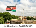 Kenya flag waving in the wind against the background of a blue cloudy sky.
