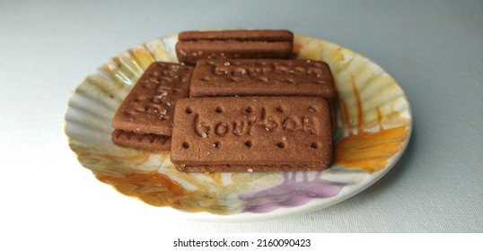 Kerala, India 24-May-2022 Typical Bourbon Dark Chocolate Cream Filled Biscuit Or Cookie On Plate. Isolated On Plain White Table Background With Copy Space. Selective Focus Clouse Up Macro Side View.