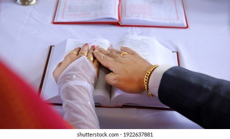 Kerala ndian christian couple taking marriage promise on an opened Bible. Marital vows or marriage promise