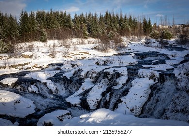 Kermoafoss Waterfall In Winter, Surrounded By The Forest In Reykjavik, Iceland. 