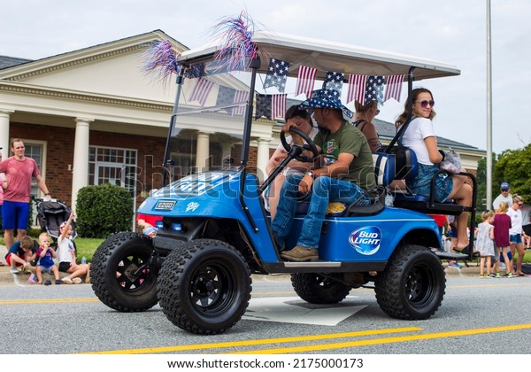 Kernersville North Carolina United States July 4, 2022 A\
blue four-wheeler go-cart drivng through the fourth of July parade\
