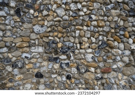 Kersey, UK - September 17 2023: Unknapped and few knapped nodules of flint, also flintstone, form of the mineral quartz used as building material in the construction of St Mary's Church Kersey.