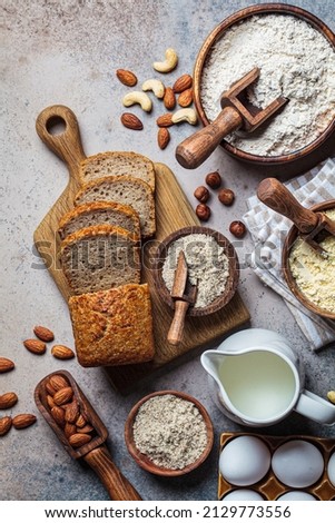 Keto bread cooking. Different types of nut flour - almond, hazelnut, cashew and baking ingredients, dark background, top view. Gluten free concept.