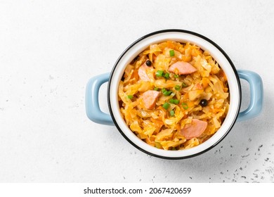 Keto cabbage stew with kielbasa in a pot. Top view, copy space.