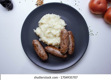 Keto diet concept with beef bangers & mash with fresh vegetable and herbs on a white background with copy space