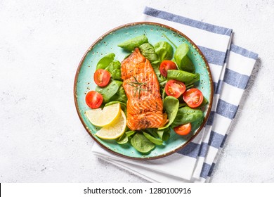 Keto Diet Food. Baked Salmon Fish Fillet With Fresh Salad From Spinach And Tomatoes. Top View On White Background.