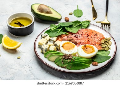 Keto diet food, salmon, avocado, cheese, egg, spinach and nuts. Ketogenic low carbs diet concept. Ingredients for healthy foods. Long banner format. top view.