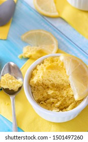 Keto Lemon Mug Cake With Almond Flour In White Mug And Blue Table