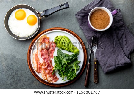 Ketogenic diet breakfast. fried egg, bacon and avocado, spinach and bulletproof coffee. Low carb high fat breakfast.