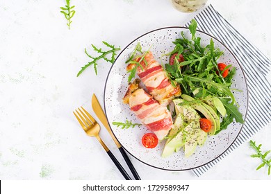 Ketogenic diet. Dinner dish with chicken meat roll wish  bacon, avocado, tomatoes and arugula. Detox and healthy concept. Keto food. Overhead, top view, flat lay