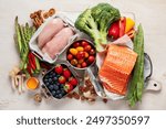 Ketogenic diet food. Healthy low carbs products. Keto diet concept. Vegetables, fish, meat, nuts, seeds, berries, cheese on a white background, top view.