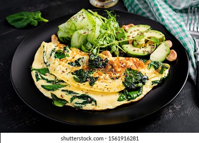 Ketogenic, paleo diet breakfast. Omelette with spinach and avocado, cucumber.