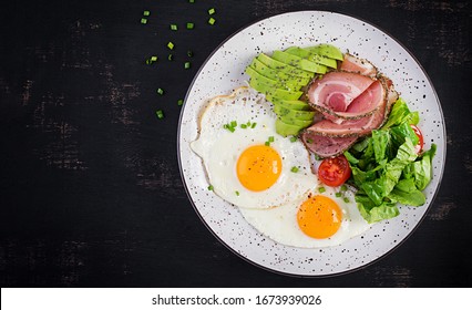 Ketogenic/paleo diet. Fried eggs, ham, avocado and fresh salad.  Keto breakfast. Brunch.  Top view, overhead