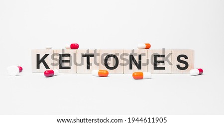 KETONES the word on wooden cubes, cubes stand on a reflective white surface. Medicine concept