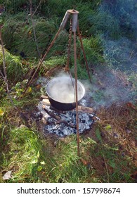 Kettle With Boiling Water On Tripod Over Campfire