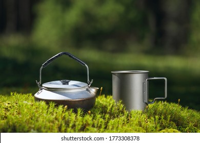 Kettle And Titanium Mug On Green Moss.