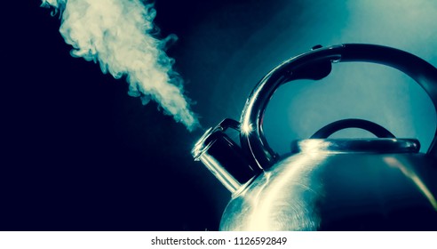 Kettle whistling, boiling kettle with steam texture on a black background. Vintage, grunge old retro style photo.