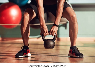 Kettlebell, fitness and hands of person for workout, exercise and development for sport. Bodybuilder, metal and legs of athlete with performance at gym for wellness, training and healthy progress - Powered by Shutterstock