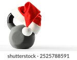 Kettlebell with red Santa Claus hat isolated on white