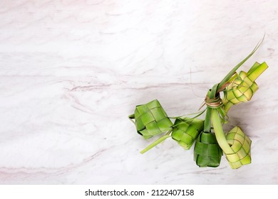 Ketupat (Indonesia) Or Rice Cube On White Marble Table. Ketupat Is Rice Dumpling With Natural Casing Made From Young Coconut Leaves. Popular During Eid Mubarak Feast. Top View.