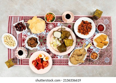 Ketupat Lebaran, Indonesian Ied Menu Dish, Opor Ayam, Sambal Goreng Ati Kentang, Balado Telur, Dates Fruit, Sambal, Lapis Legit, and Tea. Top View 