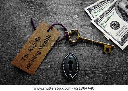   Key to building wealth, with keyhole and money                             