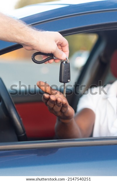 The key to the car is in the hands of an\
African-American. Buying and renting a\
car.