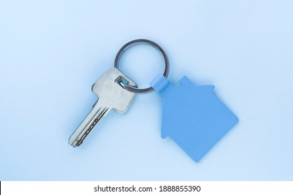 key chain with house symbol and keys on blue background,Real estate concept