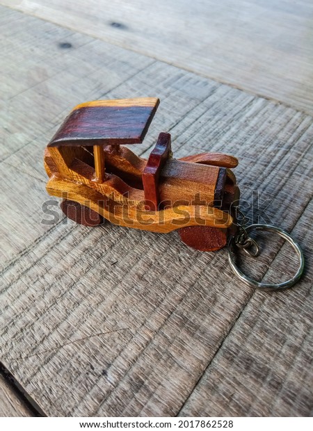 key chain made\
of wood in the shape of a\
car
