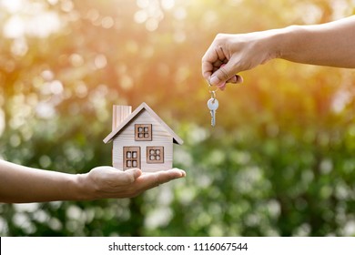 Key, home and man hands in sunlight represent to exchange or contract to rent a house or real estate or loan to buy a house or investment for the future. - Shutterstock ID 1116067544