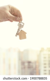 Key with house keychain in hand on background with high-rises new residential building houses. Property purchase and real estate concept - Shutterstock ID 1900788835