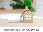 Key with house shaped keychain and contract on the table. Mortgage, home loan and insurance, buying house, real estate concept. Selective focus