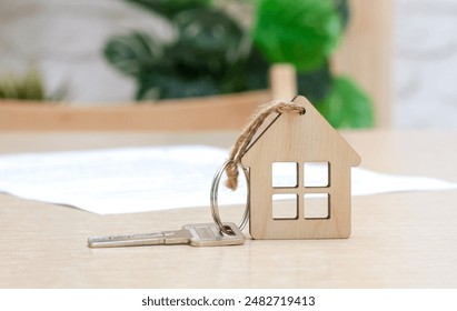 Key with house shaped keychain and contract on the table. Mortgage, home loan and insurance, buying house, real estate concept. Selective focus