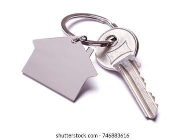 Key And Keychain In The Shape Of A House Isolated On White Background.