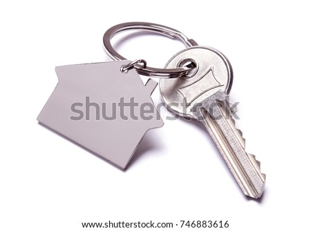 Key and keychain in the shape of a house isolated on white background.