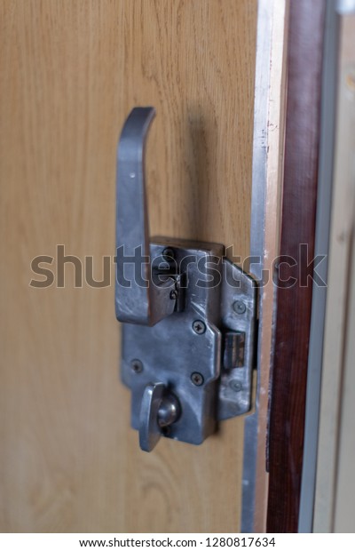 the key mechanism and the handle on a sliding door
of a compartment from the inside of the compartment of the car of
the passenger train in Russia against the panel decorated under a
tree
