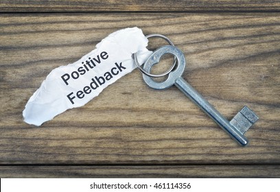 Key With Message Positive Feedback On Wooden Table