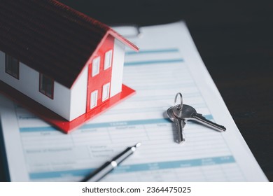 Key with model home on wooden table, Save money concept, Property investment, house loan, reverse mortgage, gold coins money stack growth, saving money coins stack future for home - Powered by Shutterstock