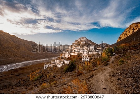 Key Monastery (Kye Gompa) glows at golden hour above the Spiti River, framed by rugged Himalayan peaks and prayer flags—serene, photogenic high-altitude panorama near Kaza.