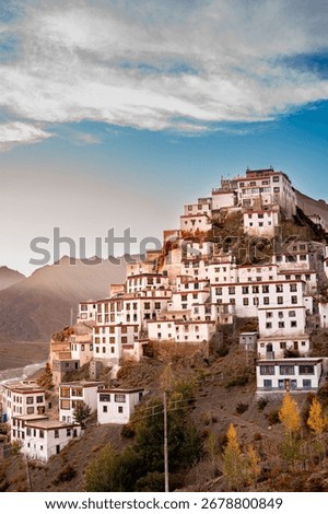 Key Monastery (Kye Gompa) glows at golden hour above the Spiti River, framed by rugged Himalayan peaks and prayer flags—serene, photogenic high-altitude panorama near Kaza.
