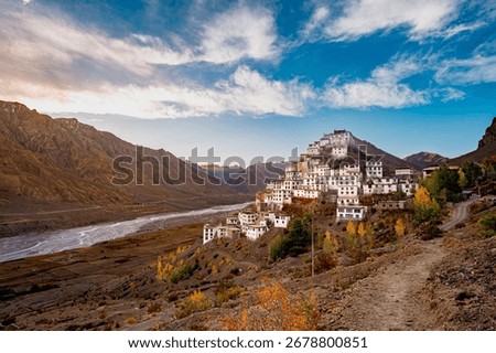 Key Monastery (Kye Gompa) glows at golden hour above the Spiti River, framed by rugged Himalayan peaks and prayer flags—serene, photogenic high-altitude panorama near Kaza.