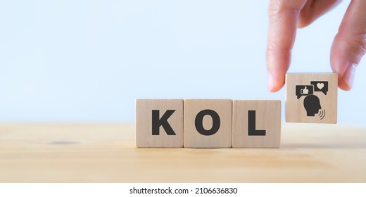 Key opinion leader (KOL) marketing concept. New social media influencer marketing in digital age. Hand holds wooden cube with KOL icon standing with abbreviation "KOL" white background and copy space.