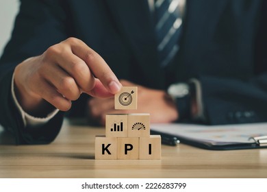 Key Performance Indicator (KPI). Businessmen arrange wood cubes with KPI icons. business goals, performance results, and indicators. For business planning and measuring success, target achievement.