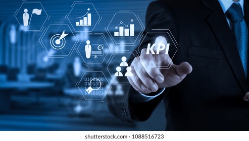 Key Performance Indicator (KPI) workinng with Business Intelligence (BI) metrics to measure achievement and planned target.Businessman hand pressing an imaginary button on virtual screen.