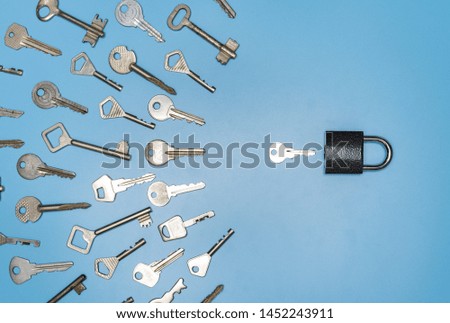 Key picking concept. Lock and different antique and new keys, blue background. Protection of business and house, real estate security.