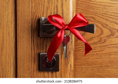 Key With Red Bow On Door Handle, Closeup View. Housewarming Party