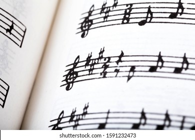 Key signature symbol and violin clef. Musical notation macro, closeup. Single line sheet music detail example, playing an instrument, learning theory abstract concept, music background, open book - Powered by Shutterstock